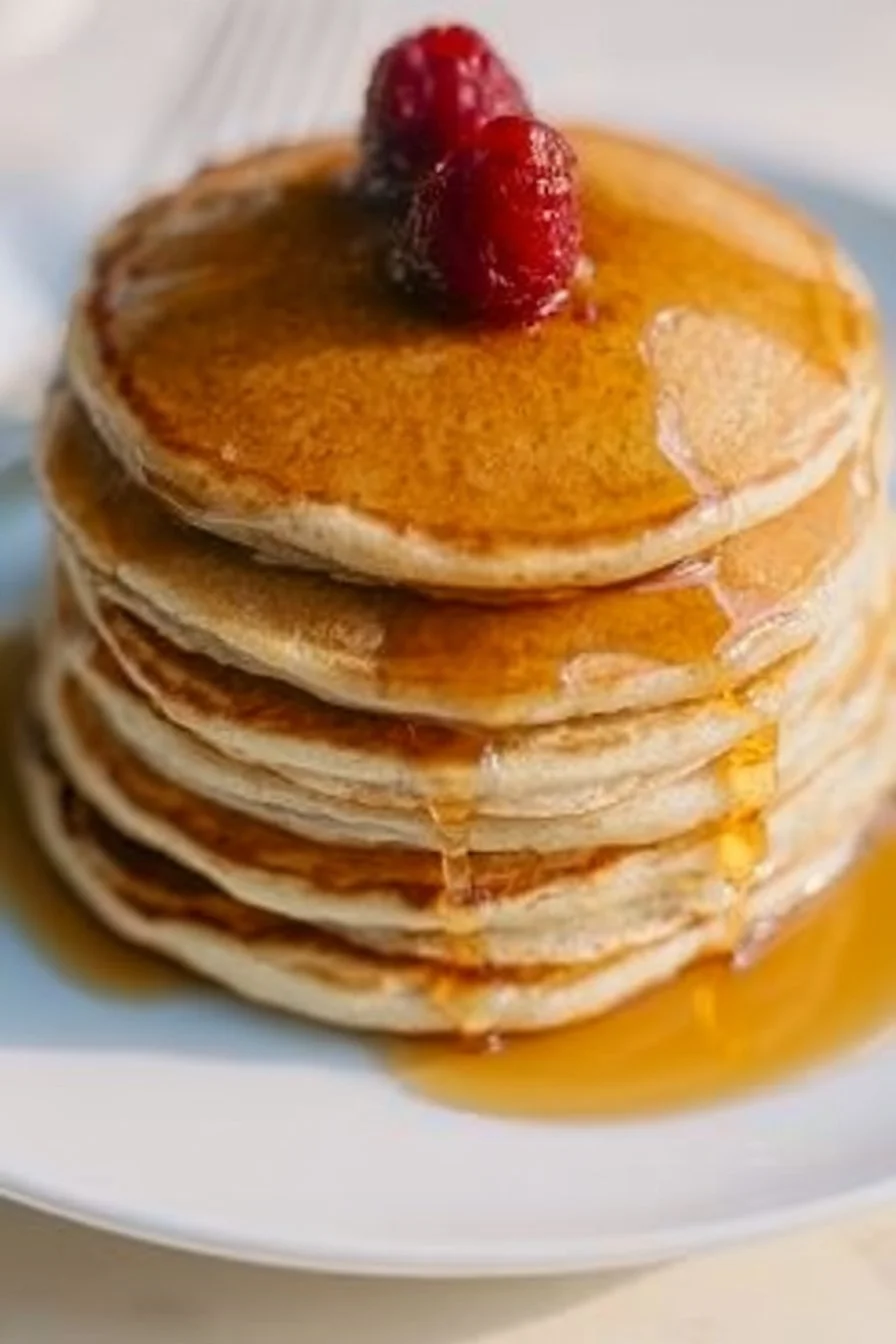 Fluffy homemade pancakes stacked with syrup and fresh berries