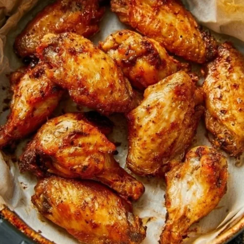 Golden chicken wings in an air fryer basket