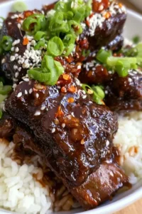 Korean braised short ribs garnished with vegetables and sauce