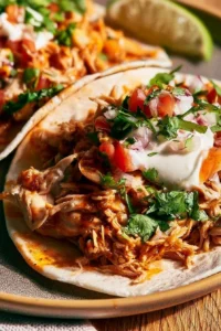 Delicious Mexican Pulled Chicken served in tacos with fresh toppings