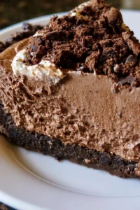 Decadent Mississippi Mud Pie topped with whipped cream and chocolate shavings.