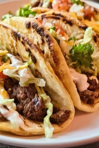 Savory smash burger tacos with beef, cheese, and toppings served on a plate.