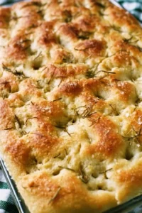 Freshly baked no-fail rosemary focaccia bread on a wooden table