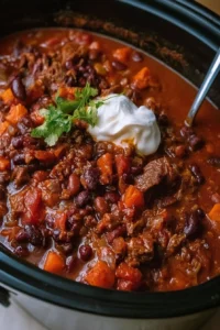 Slow cooker beef chili served in a bowl with toppings