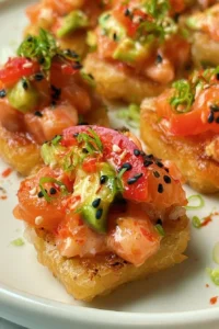 Crispy rice rounds topped with chopped salmon, avocado, and sesame seeds